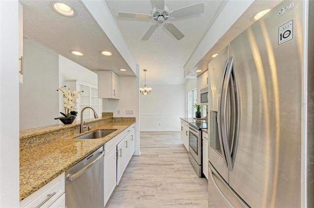 kitchen with light wood-style flooring, white cabinetry, stainless steel appliances, and a sink