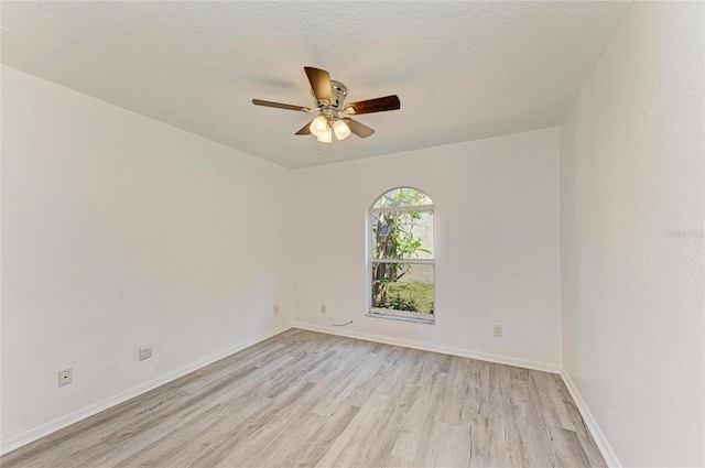 spare room with light wood finished floors, ceiling fan, baseboards, and a textured ceiling