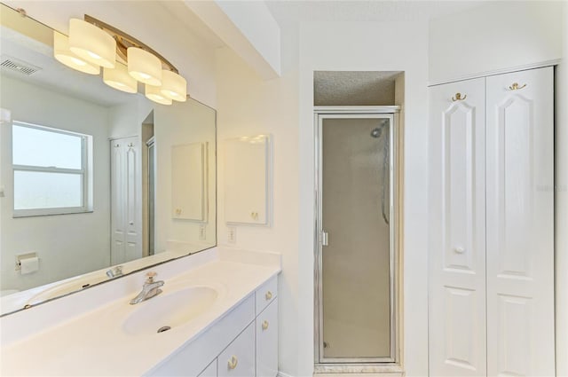 full bathroom featuring a shower stall, visible vents, and a closet