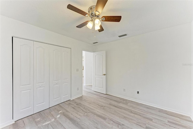 unfurnished bedroom featuring a closet, light wood-type flooring, visible vents, and baseboards