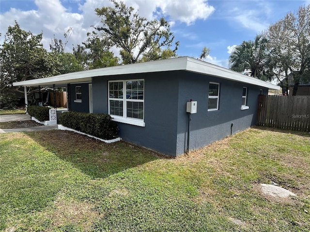 view of home's exterior featuring a yard, fence, and stucco siding