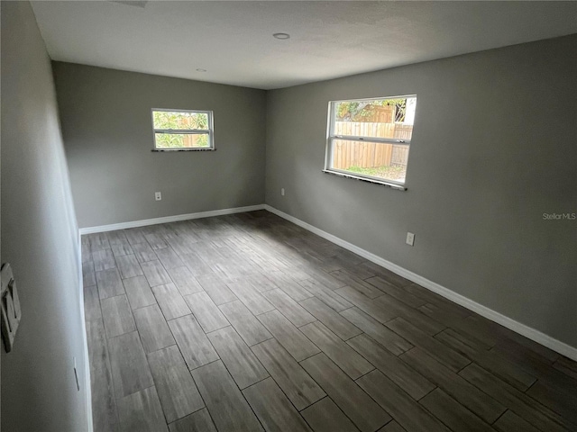 empty room with dark wood-style floors and baseboards