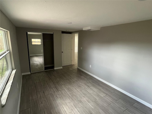 spare room featuring baseboards and wood finish floors