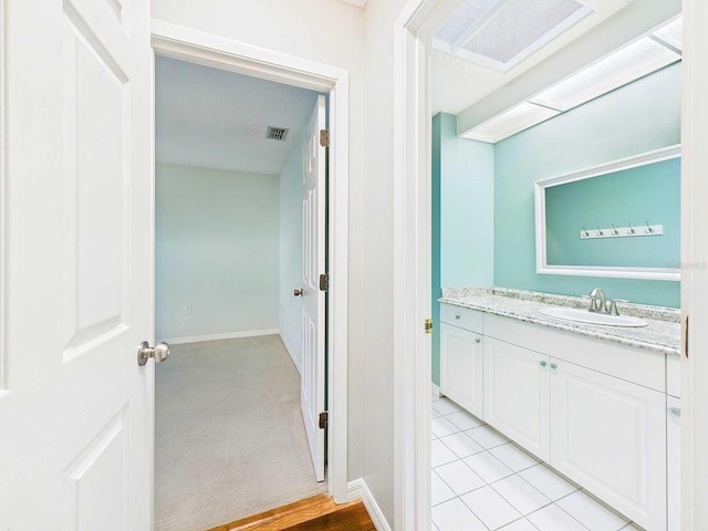 bathroom with vanity, visible vents, and baseboards