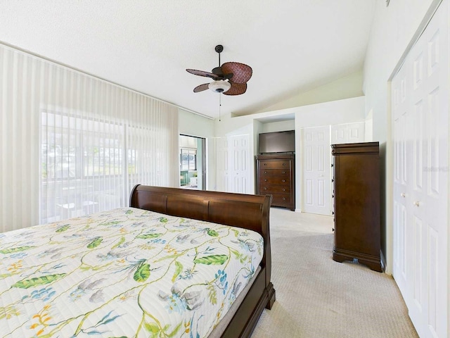 bedroom featuring lofted ceiling, ceiling fan, a closet, and light colored carpet