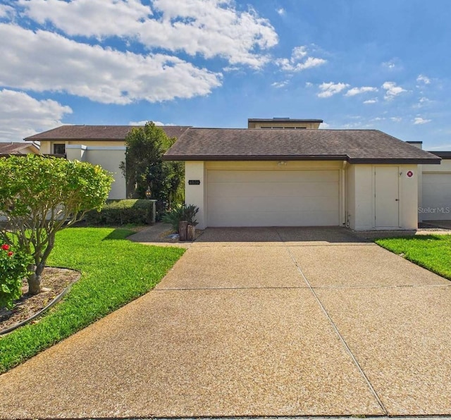 view of front of house featuring driveway, an attached garage, a front yard, and stucco siding