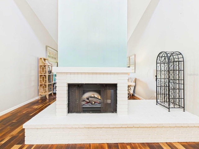 interior details with a fireplace, baseboards, and wood finished floors