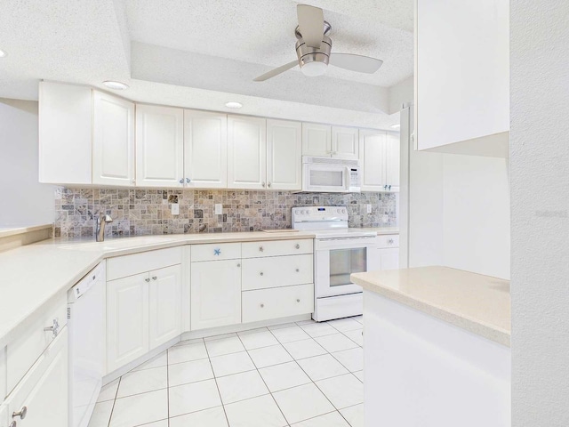 kitchen with light tile patterned floors, backsplash, white cabinetry, a sink, and white appliances