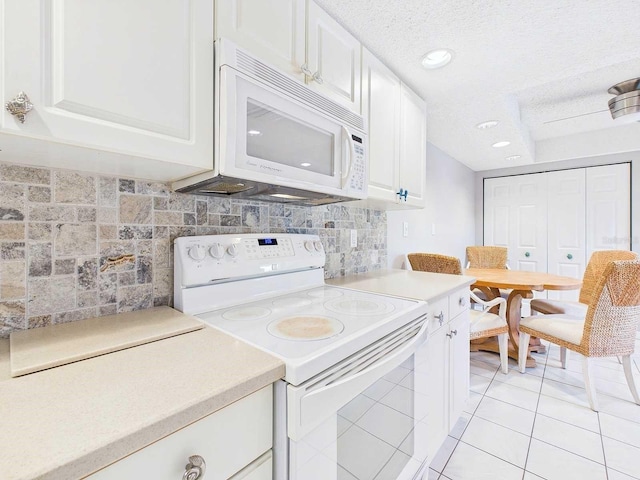 kitchen with light countertops, white appliances, white cabinetry, and backsplash