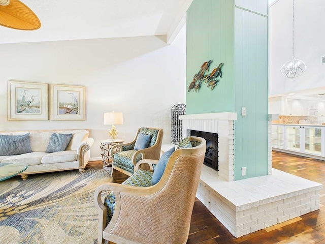 living area featuring a notable chandelier, a fireplace, and wood finished floors