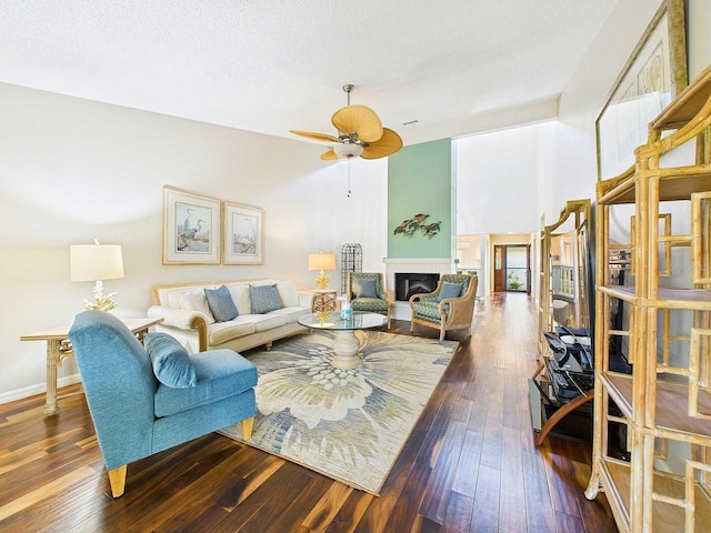 living area featuring a glass covered fireplace, a textured ceiling, and hardwood / wood-style flooring