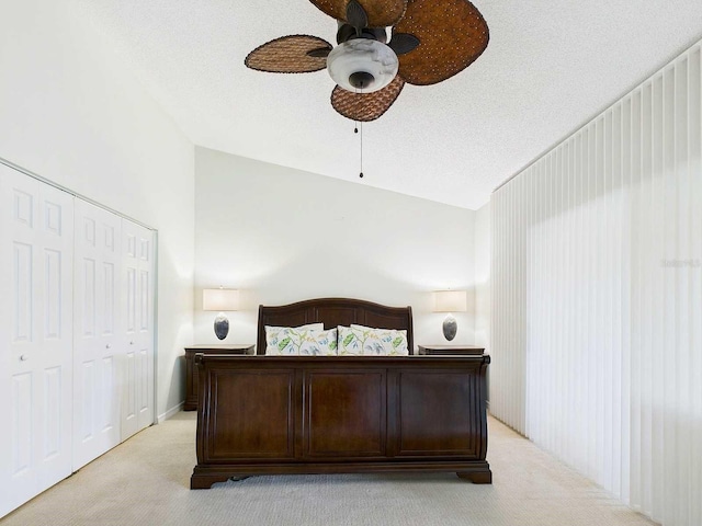 bedroom with light carpet, ceiling fan, a textured ceiling, and a closet