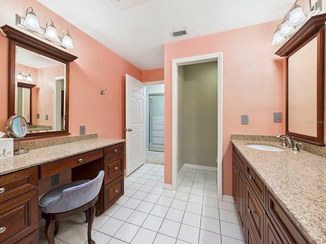 bathroom featuring visible vents, baseboards, tile patterned flooring, a textured ceiling, and vanity