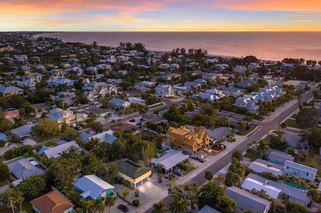 aerial view at dusk with a residential view and a water view