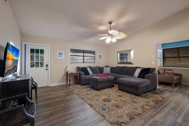 living area with ceiling fan, baseboards, lofted ceiling, and wood finished floors