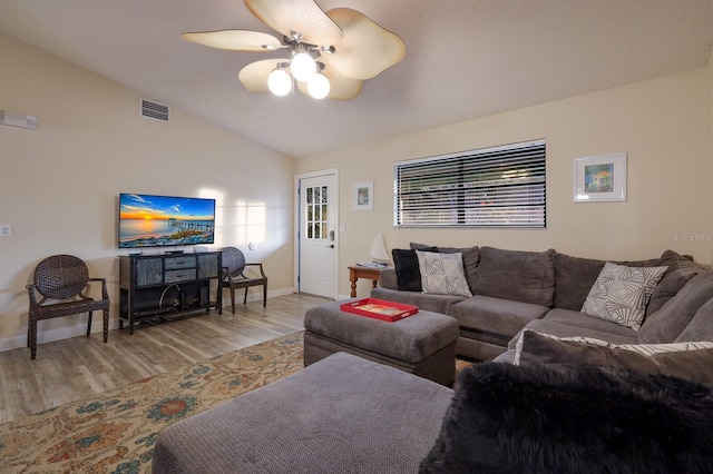 living area featuring wood finished floors, baseboards, visible vents, lofted ceiling, and ceiling fan