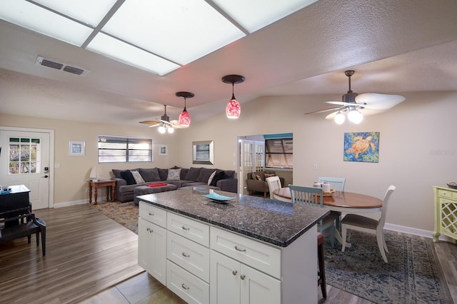 kitchen featuring visible vents, ceiling fan, decorative light fixtures, lofted ceiling, and white cabinetry