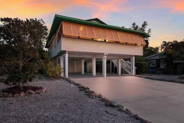 view of front facade featuring a carport, stairway, and driveway