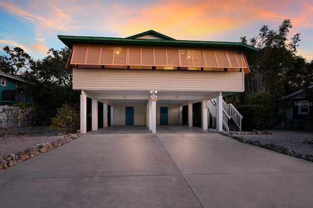 coastal inspired home featuring stairs, a carport, and driveway