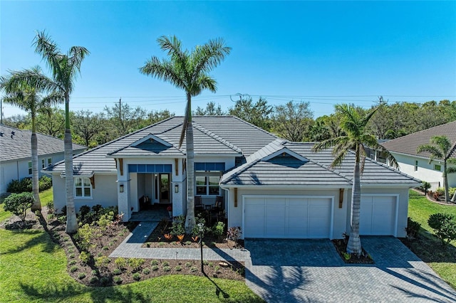 view of front of property featuring a garage, decorative driveway, and a tile roof