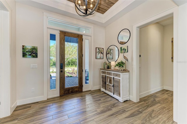 entrance foyer with light wood-type flooring, baseboards, and a chandelier