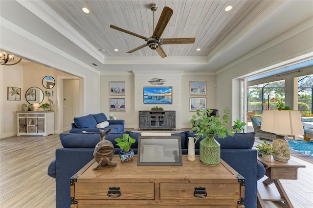 living area featuring ornamental molding, a tray ceiling, wood ceiling, and wood finished floors