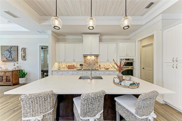 kitchen featuring double oven, visible vents, tasteful backsplash, and a sink