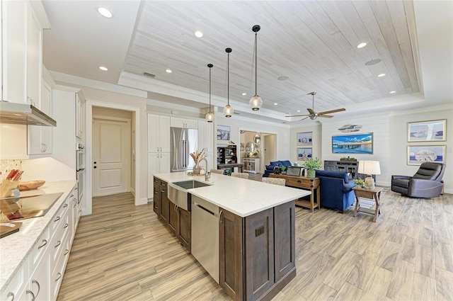 kitchen featuring stainless steel appliances, wood ceiling, a raised ceiling, and a sink