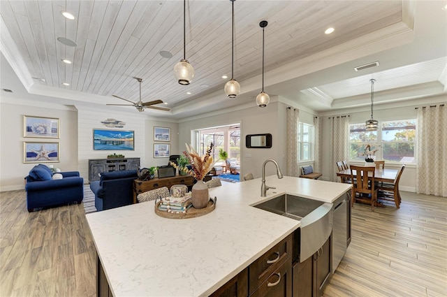 kitchen featuring wood ceiling, visible vents, a tray ceiling, and a sink