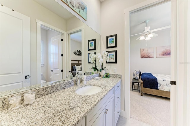 bathroom with ensuite bathroom, ceiling fan, toilet, vanity, and tile patterned floors