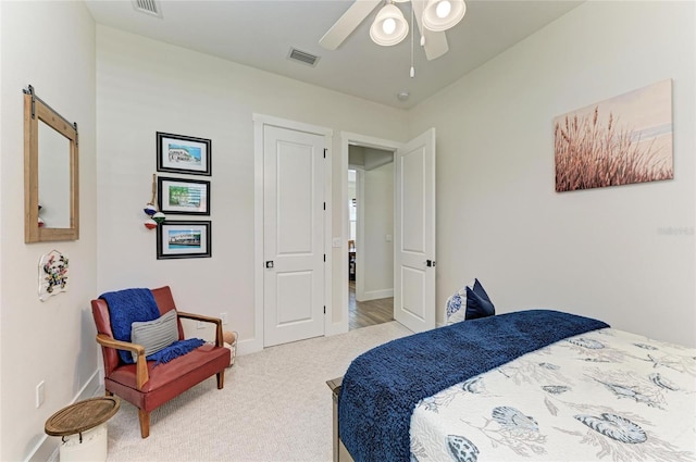 carpeted bedroom featuring ceiling fan, visible vents, and baseboards