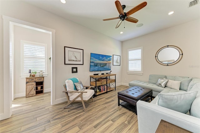 living room with light wood-type flooring, visible vents, and recessed lighting