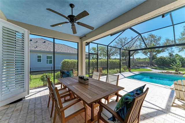 exterior space with a fenced in pool, a patio, glass enclosure, ceiling fan, and outdoor dining area