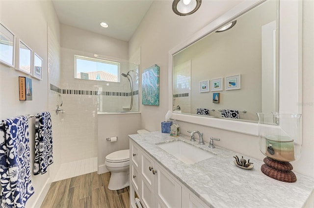 full bathroom with a walk in shower, vanity, toilet, and wood tiled floor