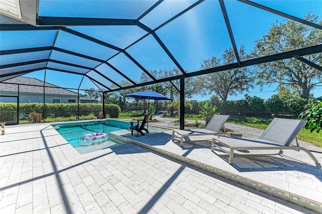 pool with glass enclosure and a patio area