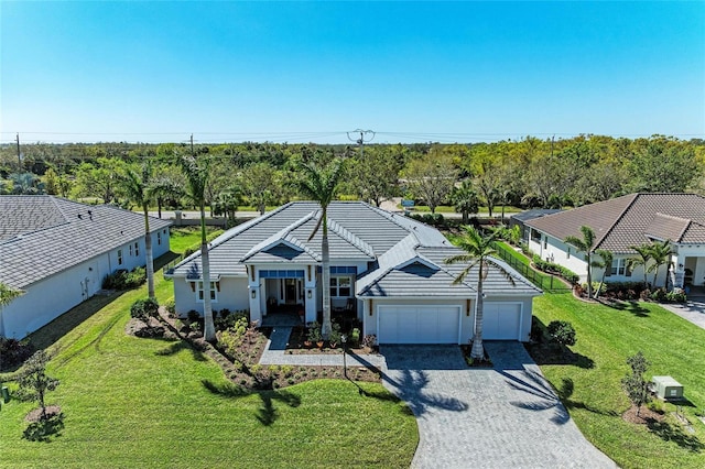 ranch-style house featuring a garage, gravel driveway, a tile roof, and a front yard