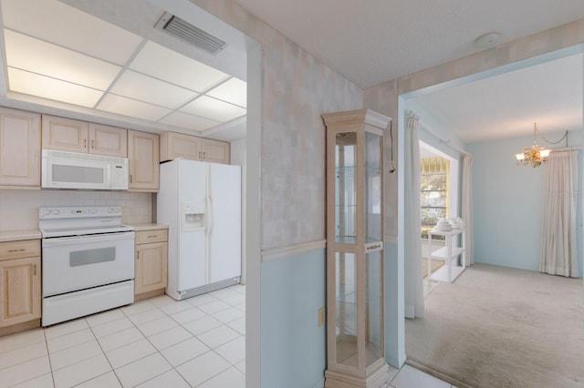 kitchen featuring white appliances, visible vents, a chandelier, and light brown cabinetry