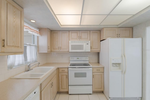 kitchen with light tile patterned floors, backsplash, light brown cabinets, a sink, and white appliances