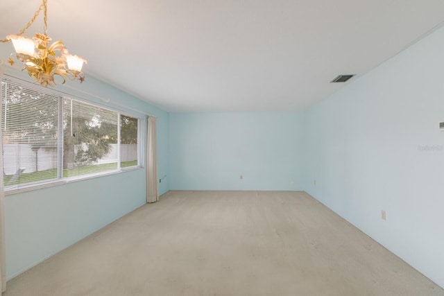 unfurnished room featuring light carpet, visible vents, and an inviting chandelier