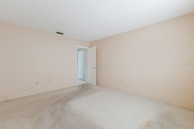 carpeted spare room featuring visible vents