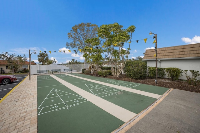 view of home's community featuring fence and shuffleboard