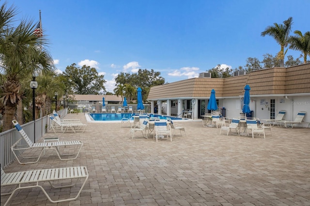 community pool with fence and a patio