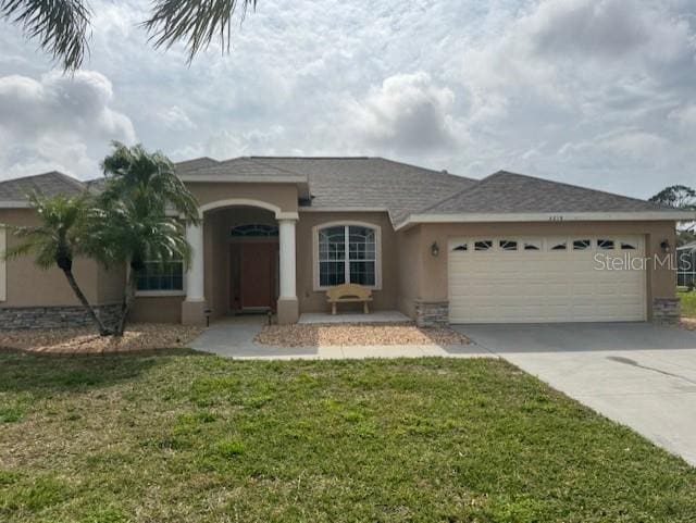 ranch-style home with a front lawn, driveway, an attached garage, and stucco siding