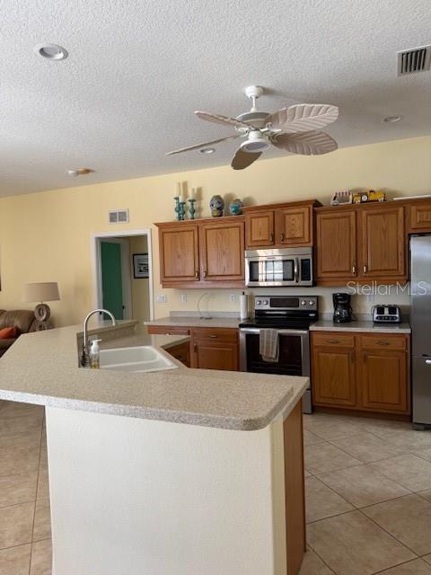 kitchen featuring visible vents, appliances with stainless steel finishes, light countertops, and a sink