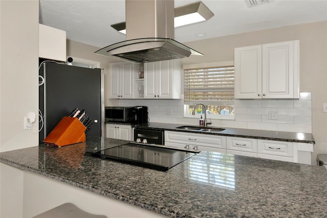 kitchen featuring decorative backsplash, appliances with stainless steel finishes, white cabinets, a sink, and island range hood