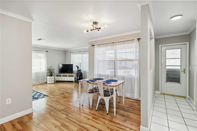 dining room with visible vents, a chandelier, crown molding, and light wood-style flooring