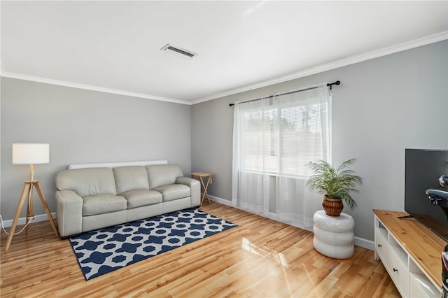 living area featuring light wood finished floors, visible vents, crown molding, and baseboards