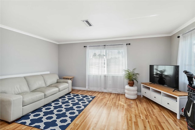 living room featuring crown molding, light wood-style floors, and baseboards