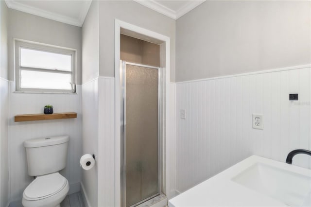 full bathroom featuring toilet, a stall shower, a sink, wainscoting, and crown molding