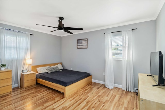 bedroom with light wood finished floors, a ceiling fan, baseboards, and ornamental molding